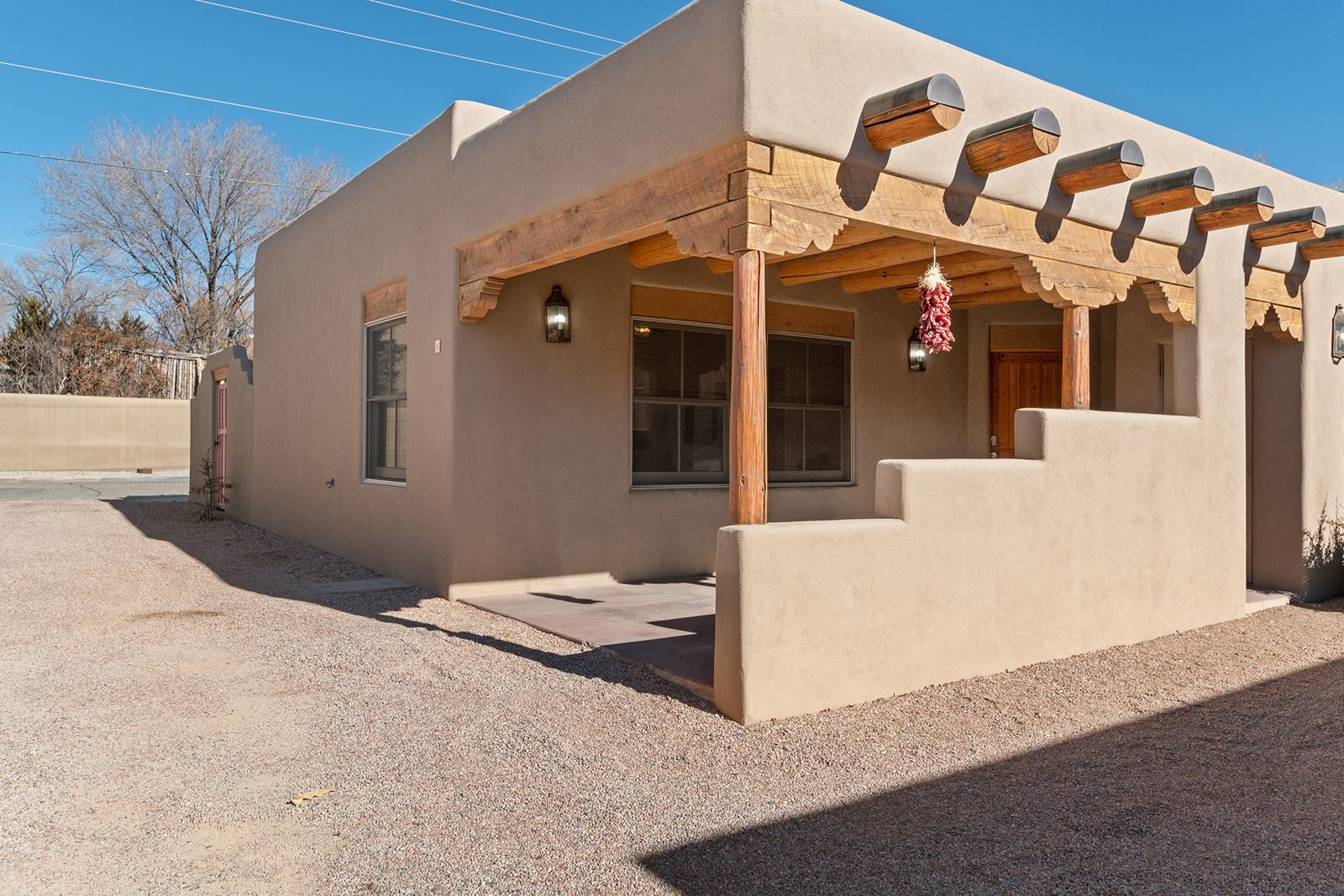 Adobe exterior with a covered portal and a chile ristra