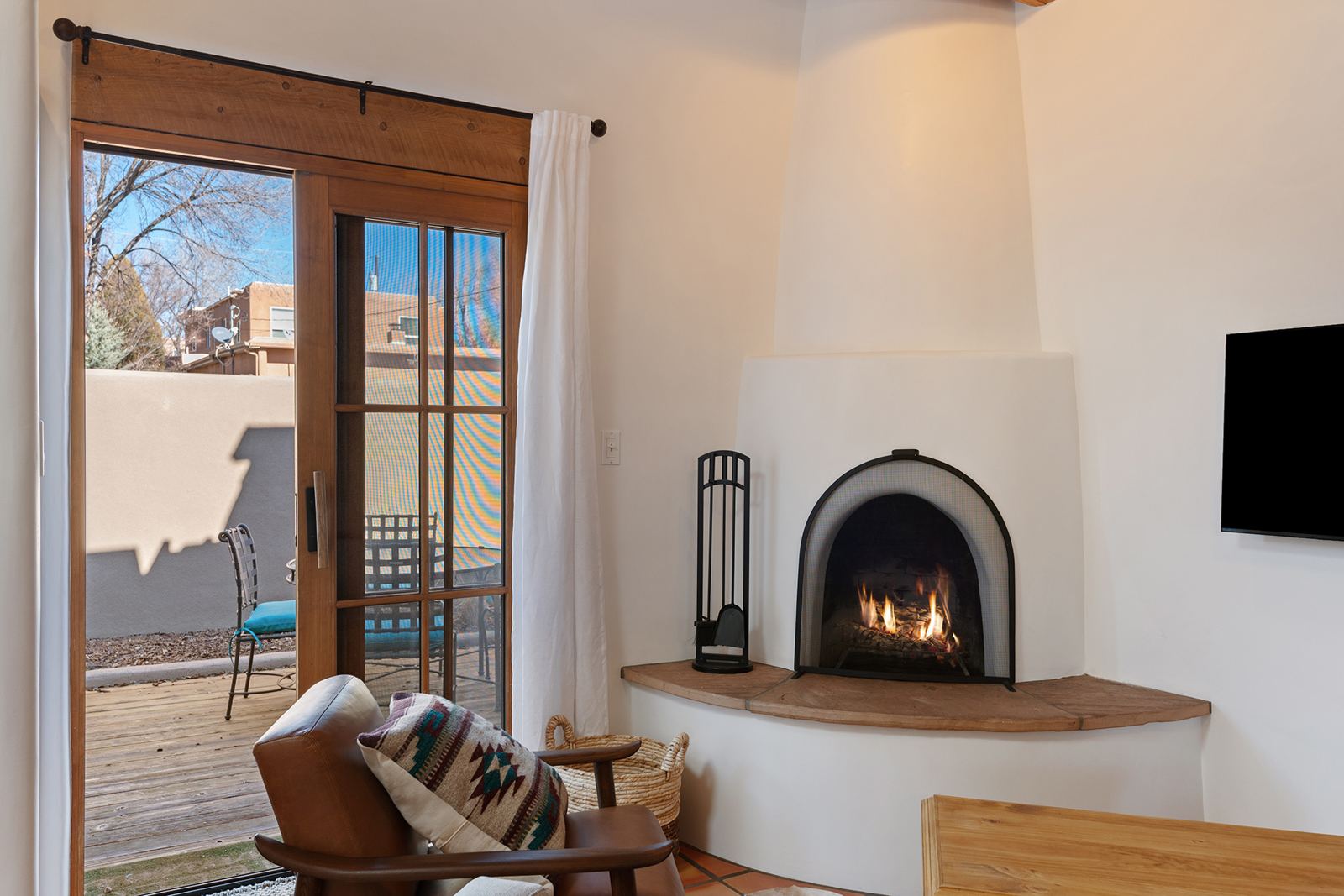 Corner kiva fireplace beside the door to the patio